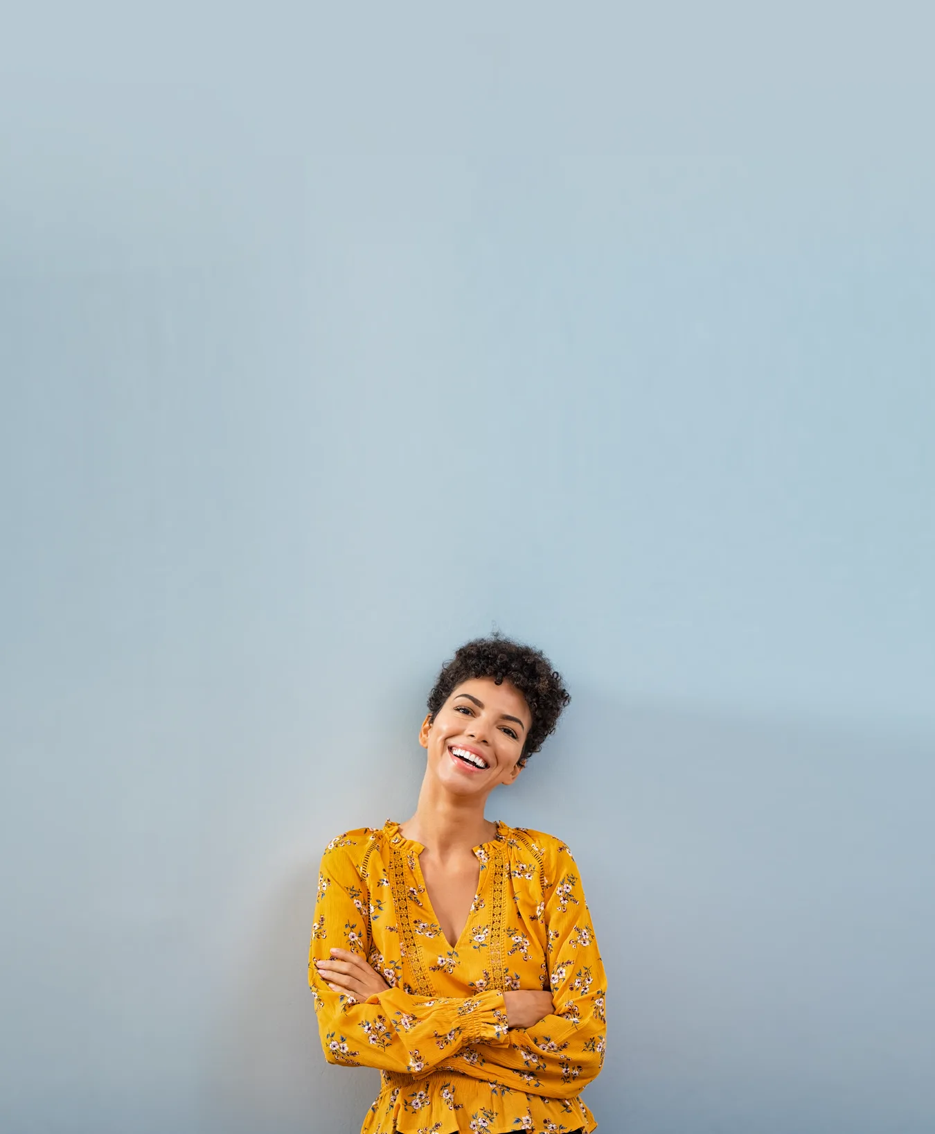 Woman standing against a wall with arms crossed